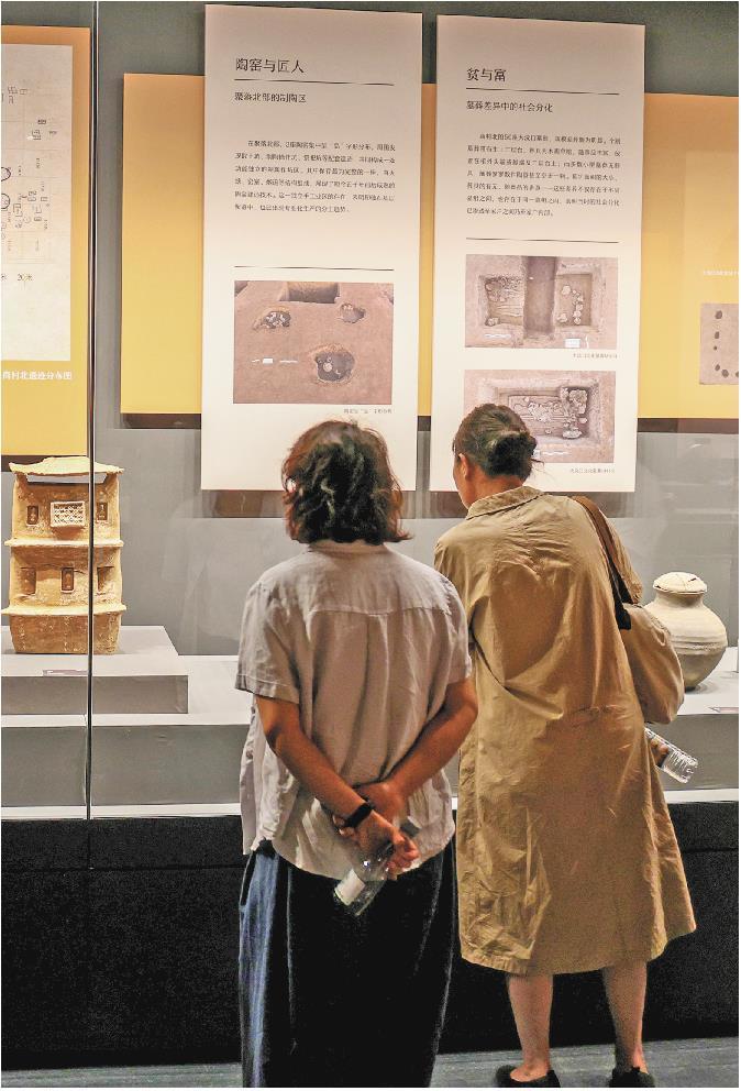 参观者在欣赏滕州商村北遗址出土的陶窑展品。(□通讯员宋海存报道)