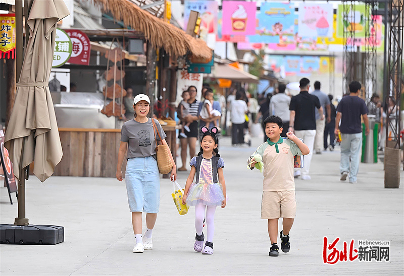 如今,塔元庄村“半城郊型”的路子越走越宽,乡亲们的日子越过越红火。图为游客在塔元庄·乡与集文化街区游玩。