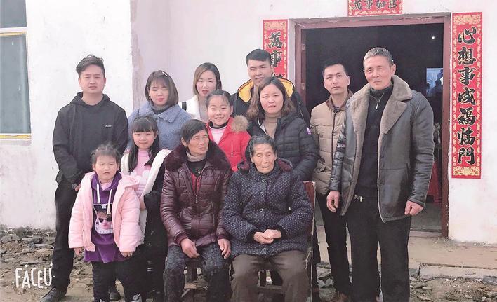 2019年,刘社彩(右一)一大家子在老屋前合影 受访者供图