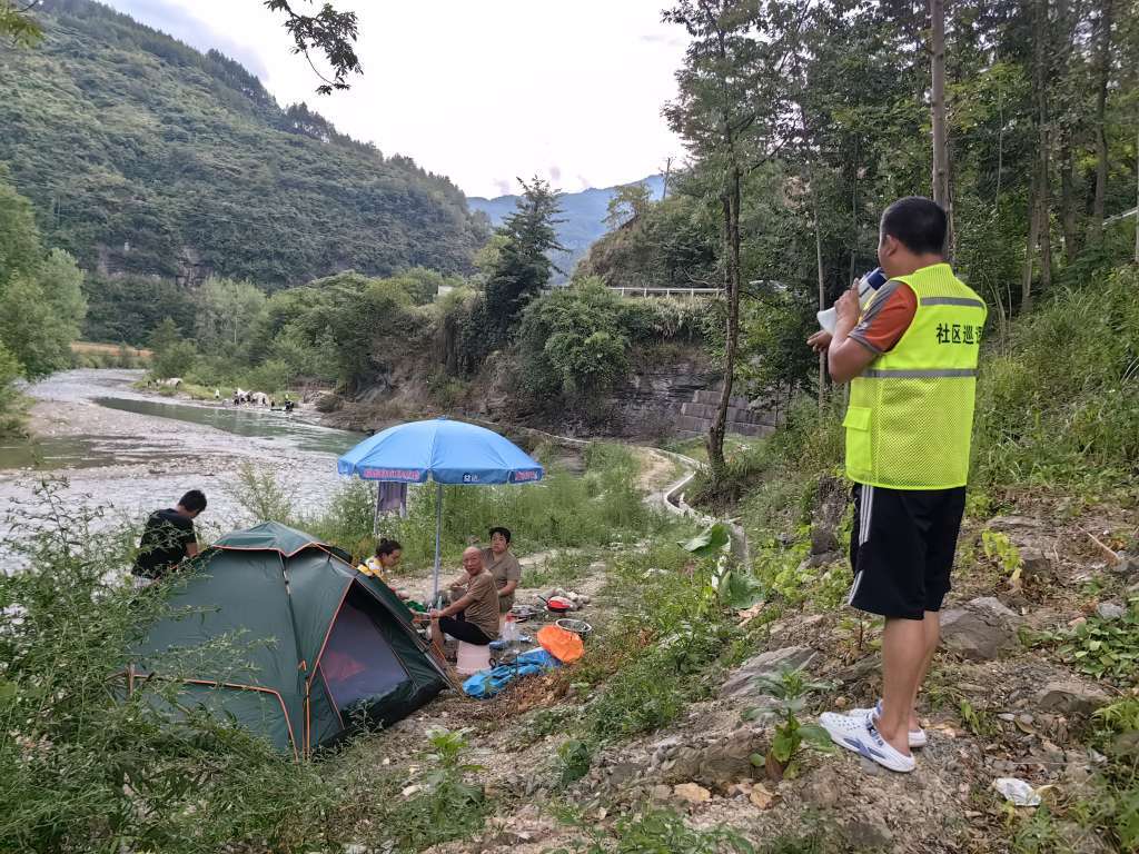 ▲强降雨天气前,南川区金山镇网格员正在劝离河道旁的游客。受访者供图