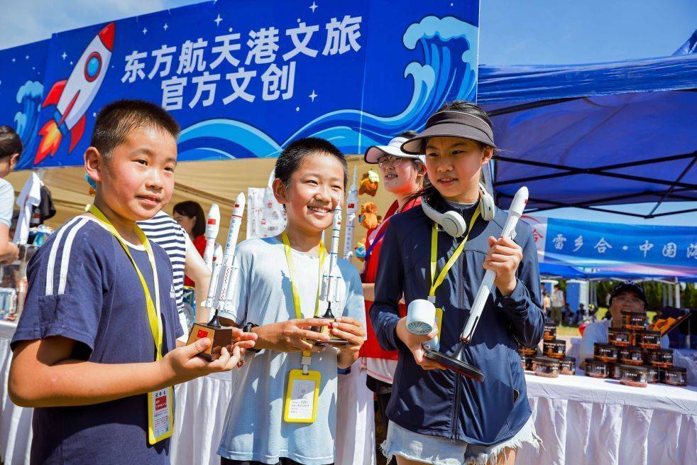 8月5日,孩子们在东方航天港展示买到的火箭模型。新华社发
