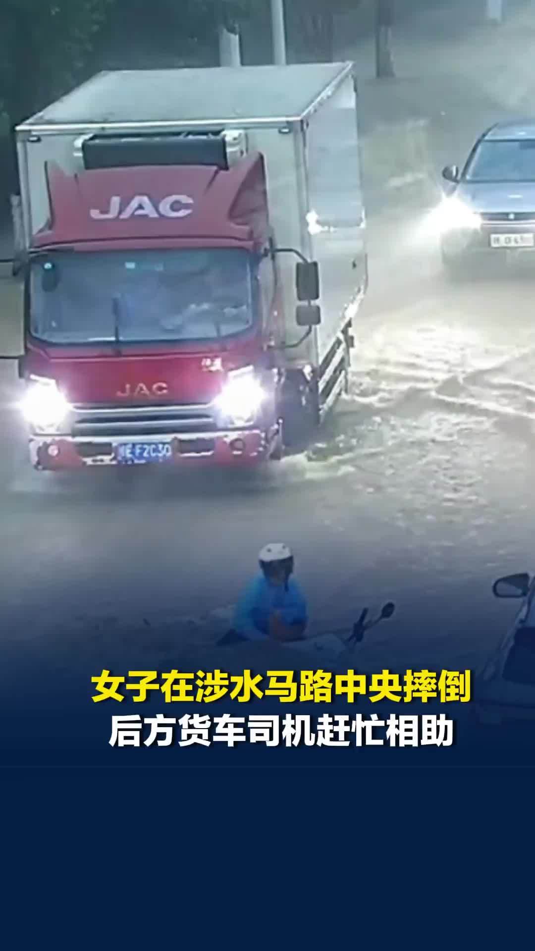 女子骑电动车涉水在马路中央摔倒，后方货车司机赶忙停车，大雨中相助