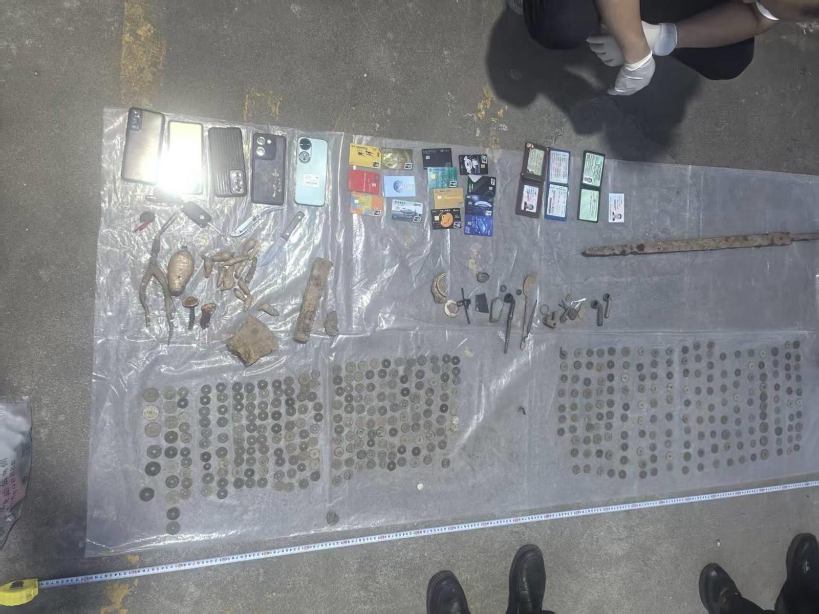 警方查获的大量古钱币等文物。