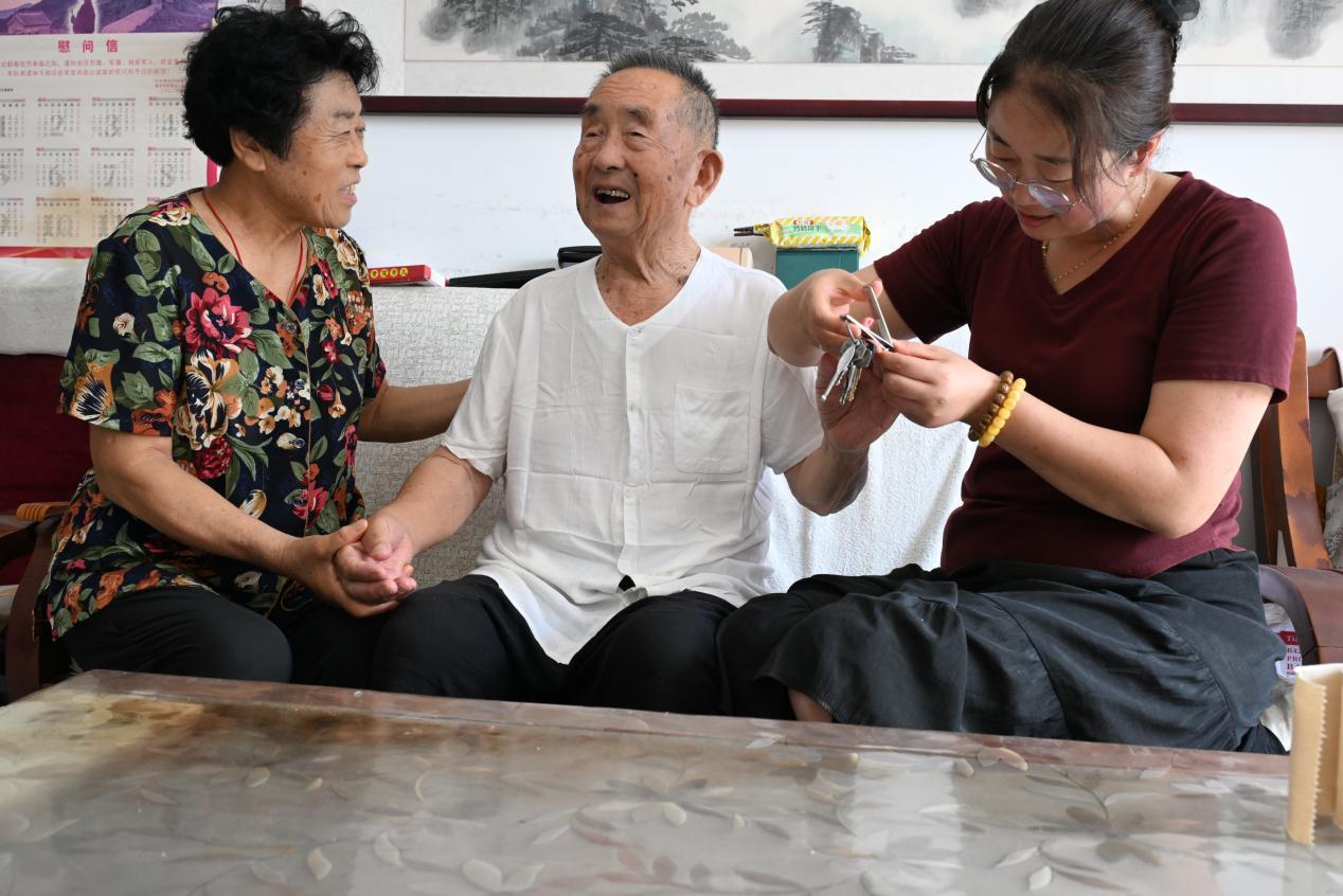 7月30日，王翠珍和儿媳妇解平利（右一）在给94岁的抗美援朝老兵周正本修剪指甲。