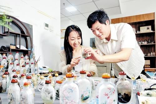 8月3日，衡水众成创业基地的雅艺内画工作室内，内画艺人张素雅（左）、吴光远在探讨内画作品内容创新。本报记者 焦 磊摄