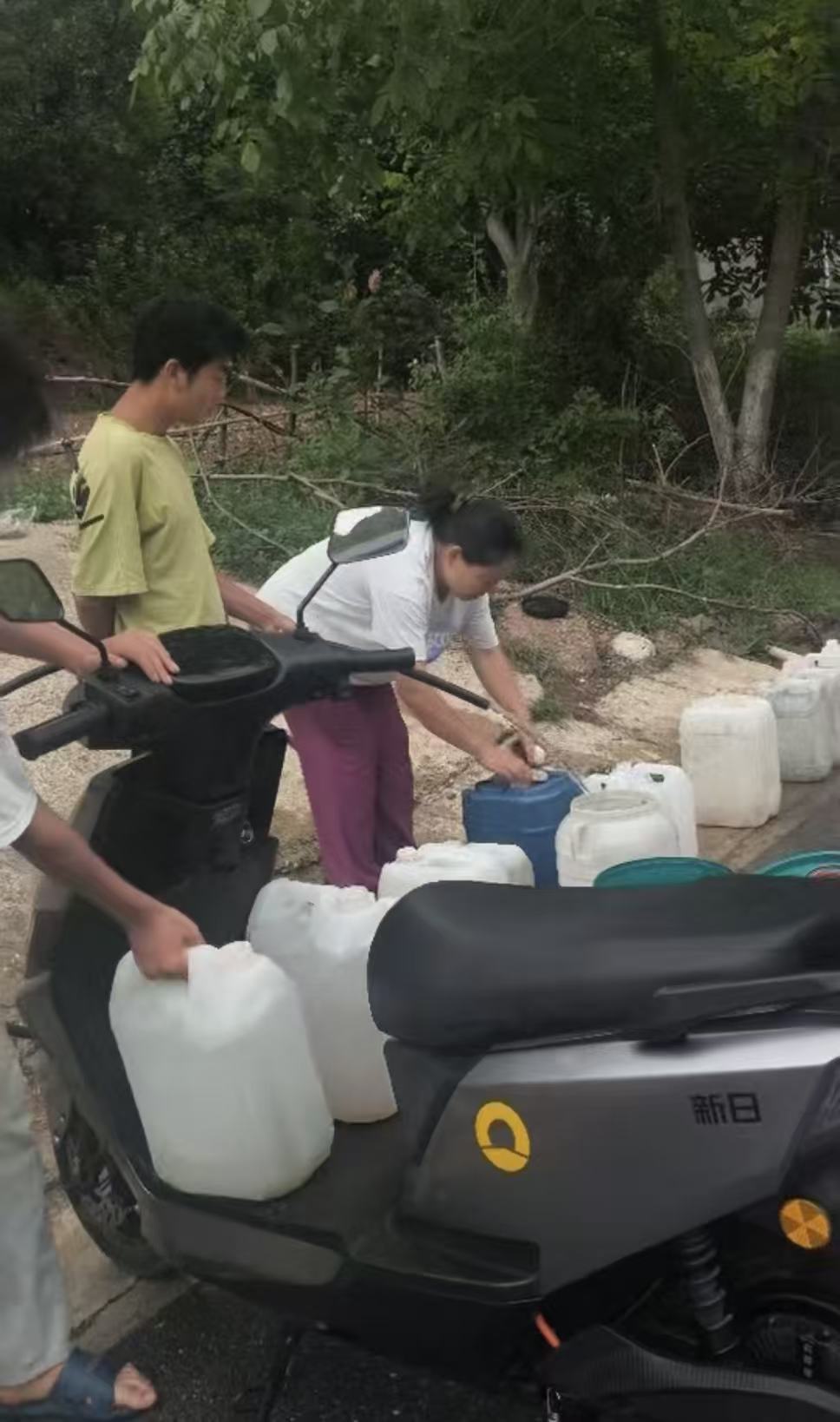 因干旱缺水，当地村民只能靠人力背水、用三轮车和电瓶车跨区域拉水。受访者供图