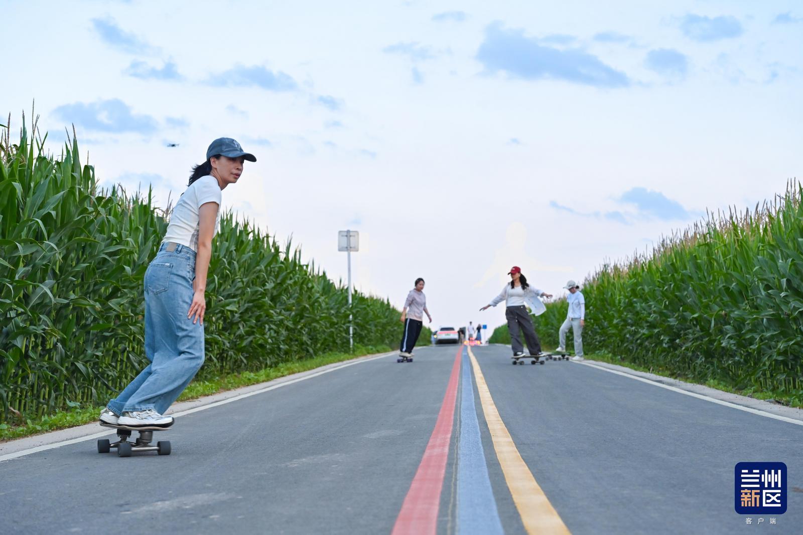青年踩着滑板行驶在田园公路,追风享受户外休闲时光。