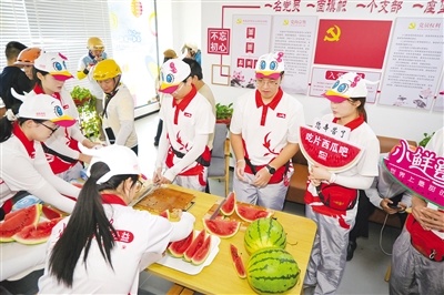 志愿者们将切好的西瓜整齐码放在托盘上