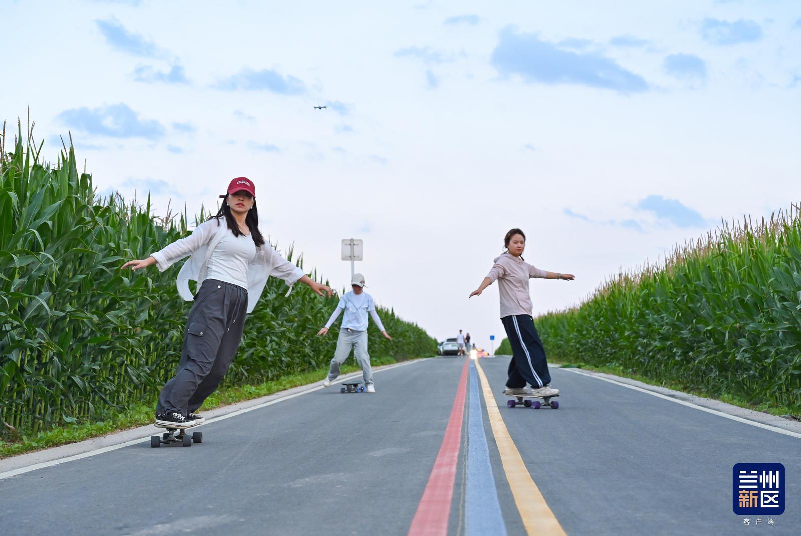 青年踩着滑板行驶在田园公路,追风享受户外休闲时光。