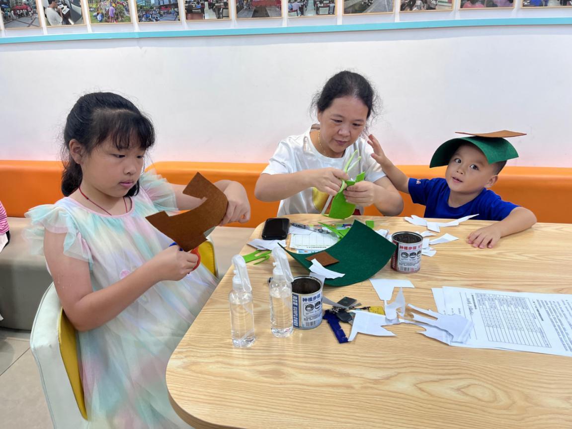 图四：家长正在专注地帮助孩子做手工。