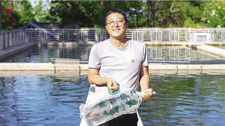 徐家峡村党支部书记宿敬龙为游客打捞虹鳟鱼