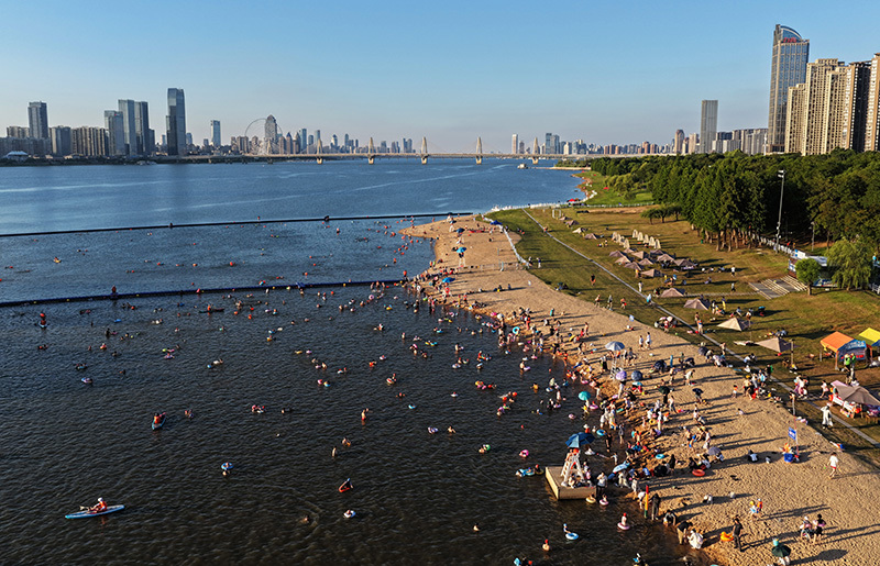 8月4日，南昌市西湖区朝阳江滩公园万紫&middot;千红滩露天泳场，市民游客在赣江中游泳戏水。