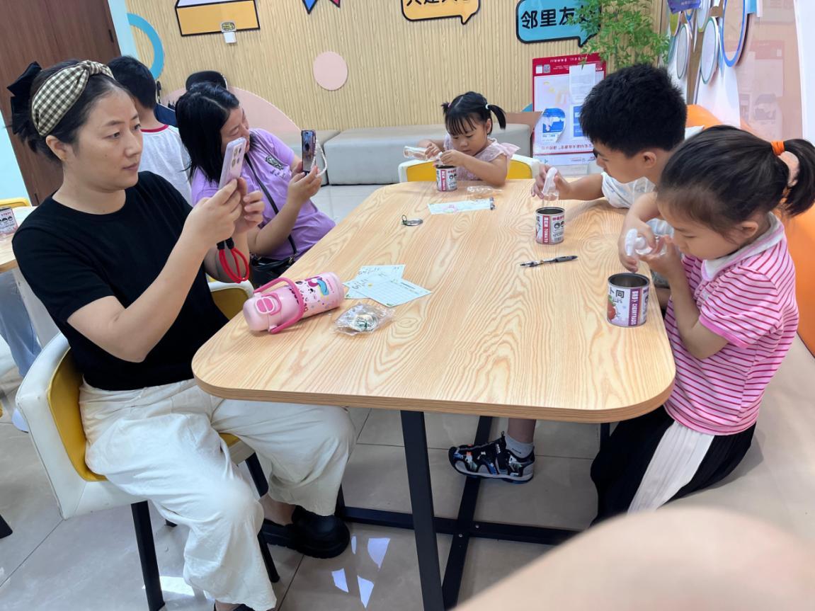 图三：孩子们沉浸在与绿植的对话中，他们小心翼翼地为盆栽喷洒清水；