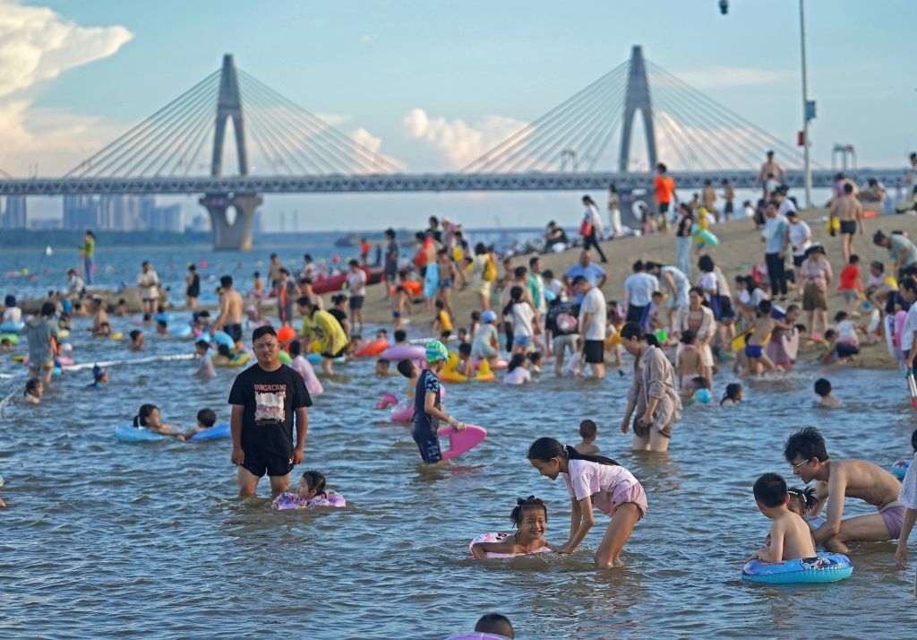 资料图:游人在位于江西省南昌市红谷滩区的摩天湾天然泳场戏水纳凉。新华社记者 万象 摄