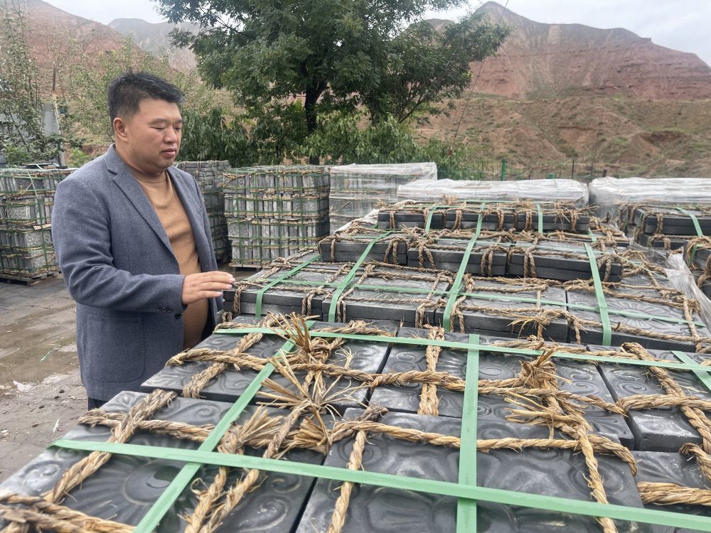 强安兴向记者介绍仿古花纹地砖产品 新华社记者 程楠 摄