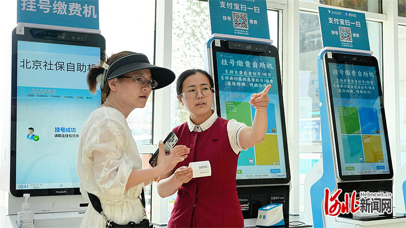 7月30日，三河市河北燕达医院工作人员（右）引导北京医保患者到相关科室就诊。河北日报记者 王伟摄