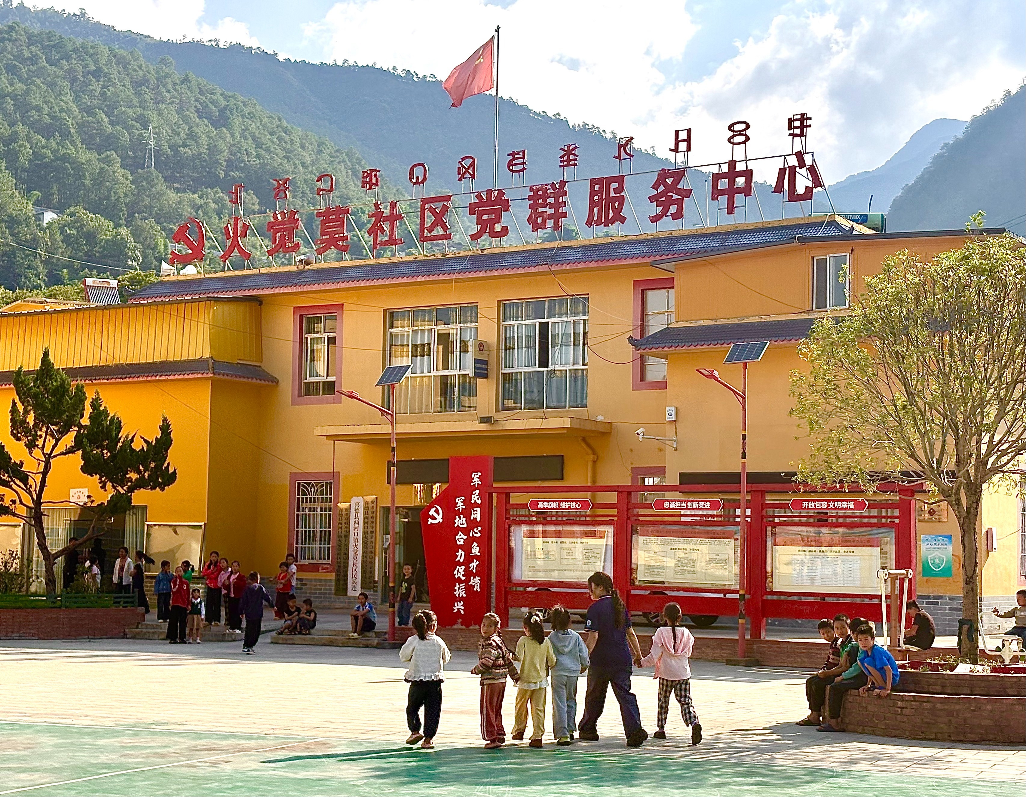 孩子们牵着刚下车的志愿者走向活动场地 任然/摄