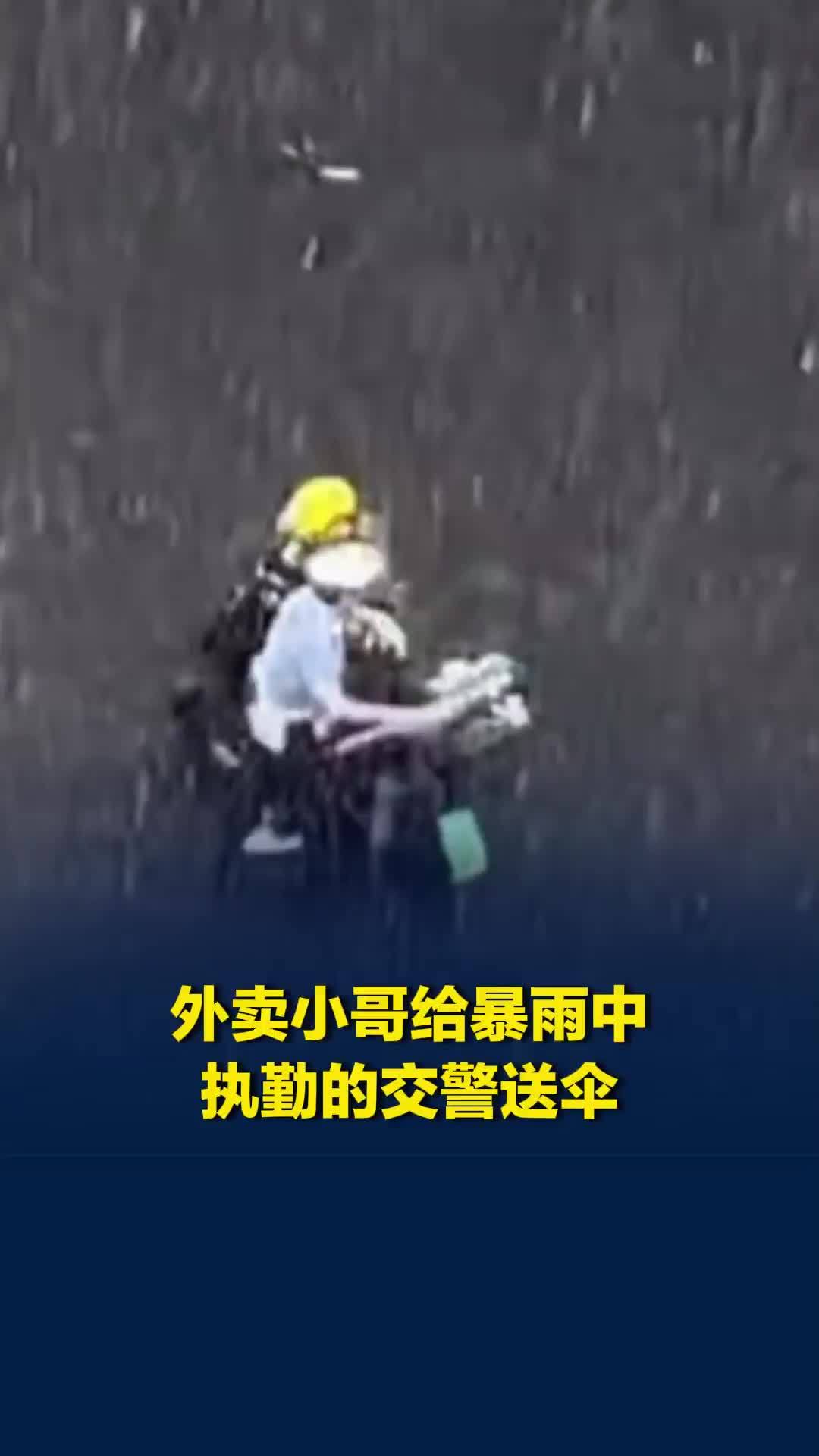 哈尔滨一交警暴雨中指挥交通，外卖小哥递上雨伞，这画面太暖了