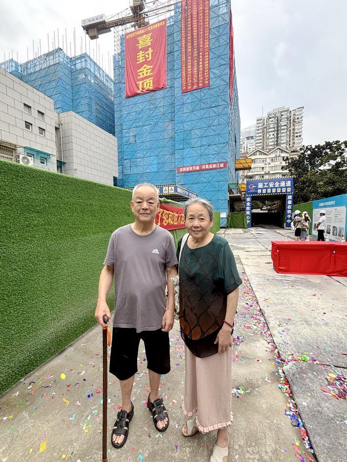 张婆婆和老伴在新楼前留影