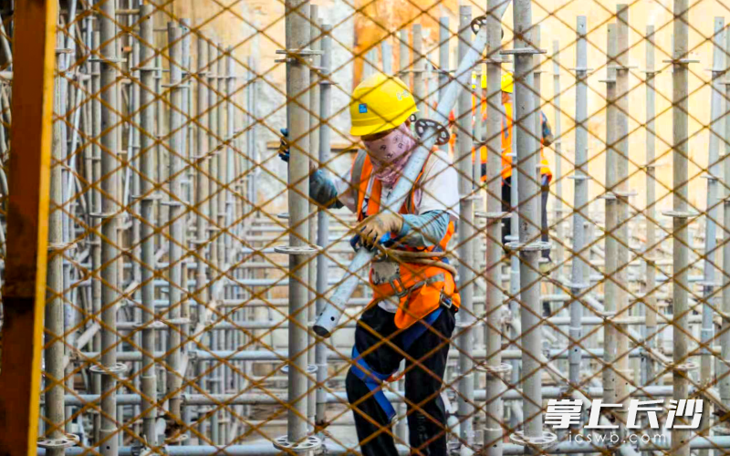 工作人员在长沙地铁4号线北延线旺旺东路站基坑内作业。