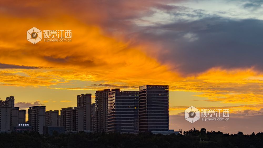 城市楼宇矗立天际之下,明暗云层交织,定格风雨将至时震撼绚烂的城市黄昏。