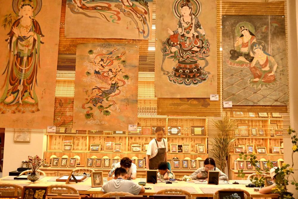 8月13日，游客在甘肃省敦煌印局体验临摹敦煌壁画。