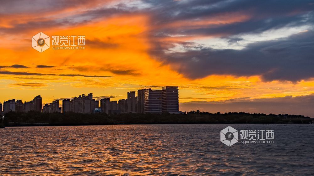 橙红流云气势磅礴,湖水泛着粼粼波光,城市楼宇静静伫立岸边,尽显风暴将至之际瑰丽又壮阔的水岸暮色。