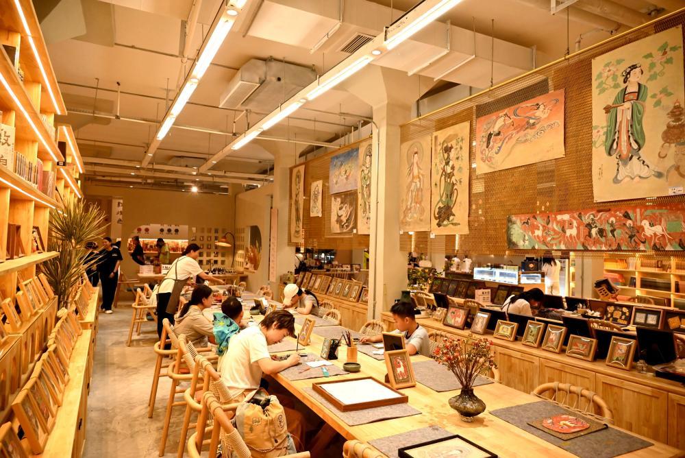 8月13日，游客在甘肃省敦煌印局体验临摹敦煌壁画。