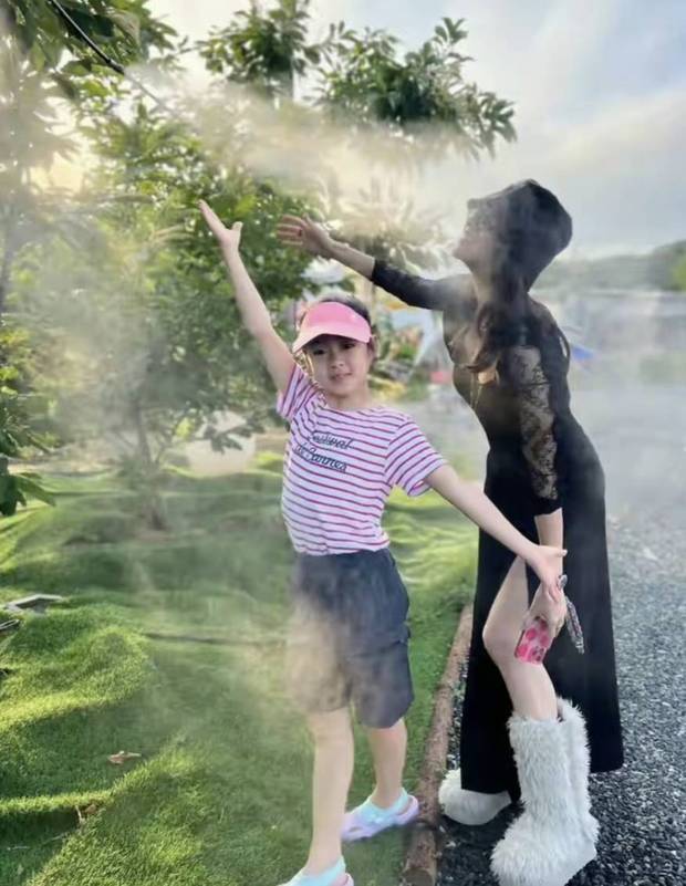 章子怡陪孩子与水雾互动。