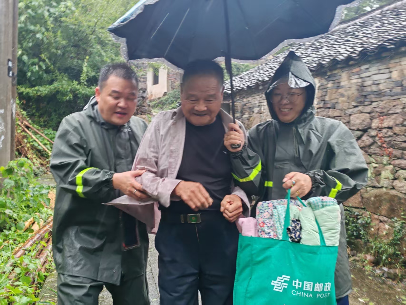村干部搀扶老人转移