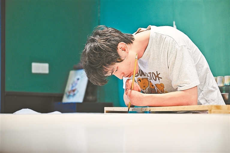 埋头创作瓷画。
