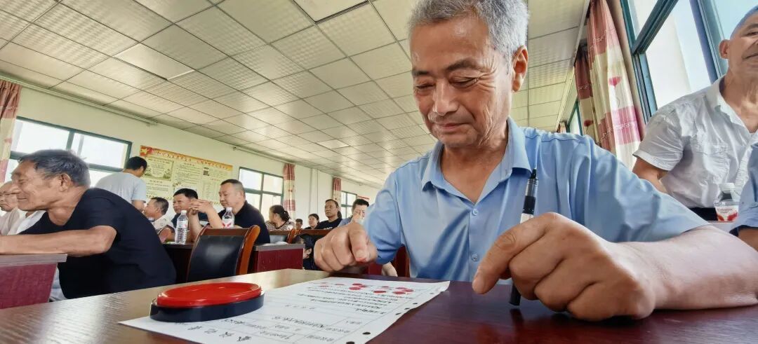 ▲8月8日，安徽和县陶店村召开村民代表大会，村民代表、电影《团圆》的原型张定泉按下红手印。