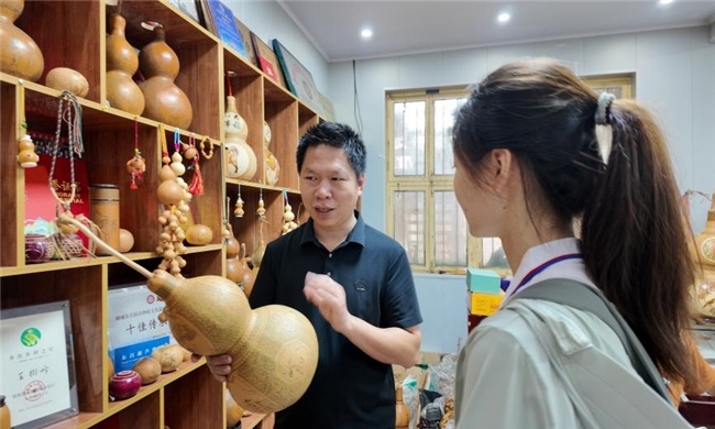 图为王树峰向实践团成员介绍作品内涵。马蔚然 供图