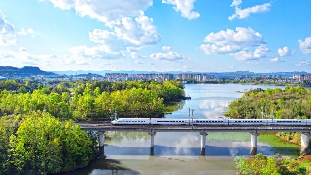 双桂街道响水村,蓝天白云之下,高铁驰骋而过,呈现出城市与生态和谐共生的宜居质感。资料图 向成国 摄