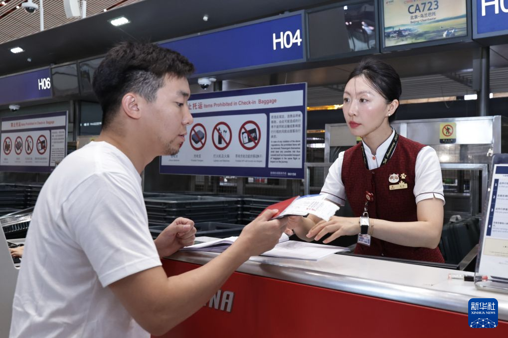 8月12日,工作人员在北京首都国际机场为国航CA723航班的乘客办理值机手续。新华社记者 张玉薇 摄
