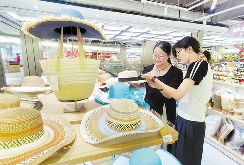 8月13日，大名县“一品一播”跨境电商产业园草编展台前，两名消费者在挑选草编制品。 大名草编是国家级非物质文化遗产，产品有草帽、草垫等多个品类，远销日本、韩国、欧美、中东等国家和地区。本报记者 陈 正摄