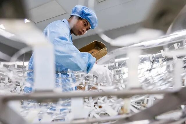 17Y在江西科强光学有限公司镀膜车间，工人将镜片放置在镀膜伞架中准备镀膜。.jpg