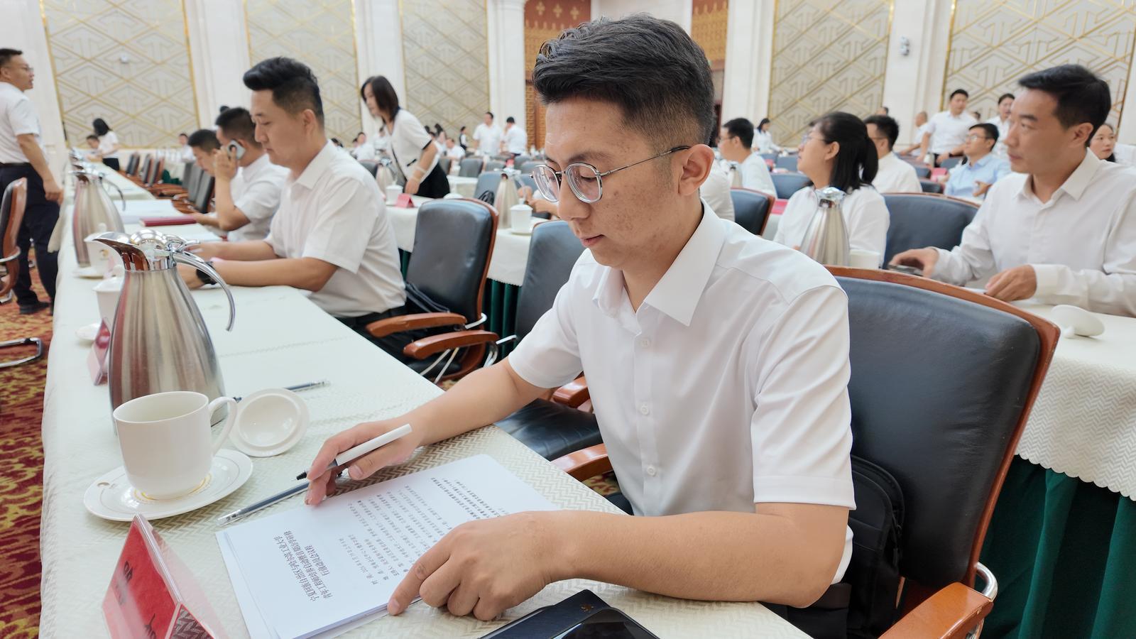 路旭认真翻阅相关政策文件。