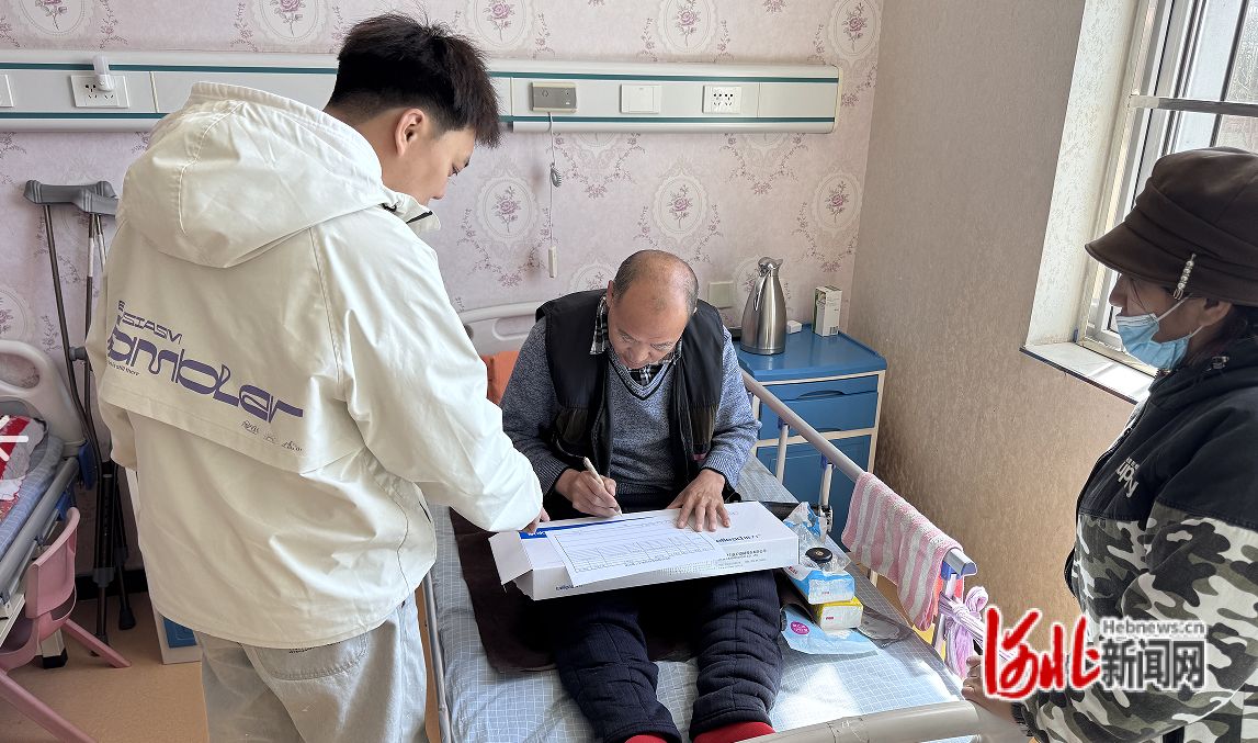 街道社会救助窗口工作人员到松鑫养老院为双腿瘫痪困难居民履行低保办理手续。车轩摄