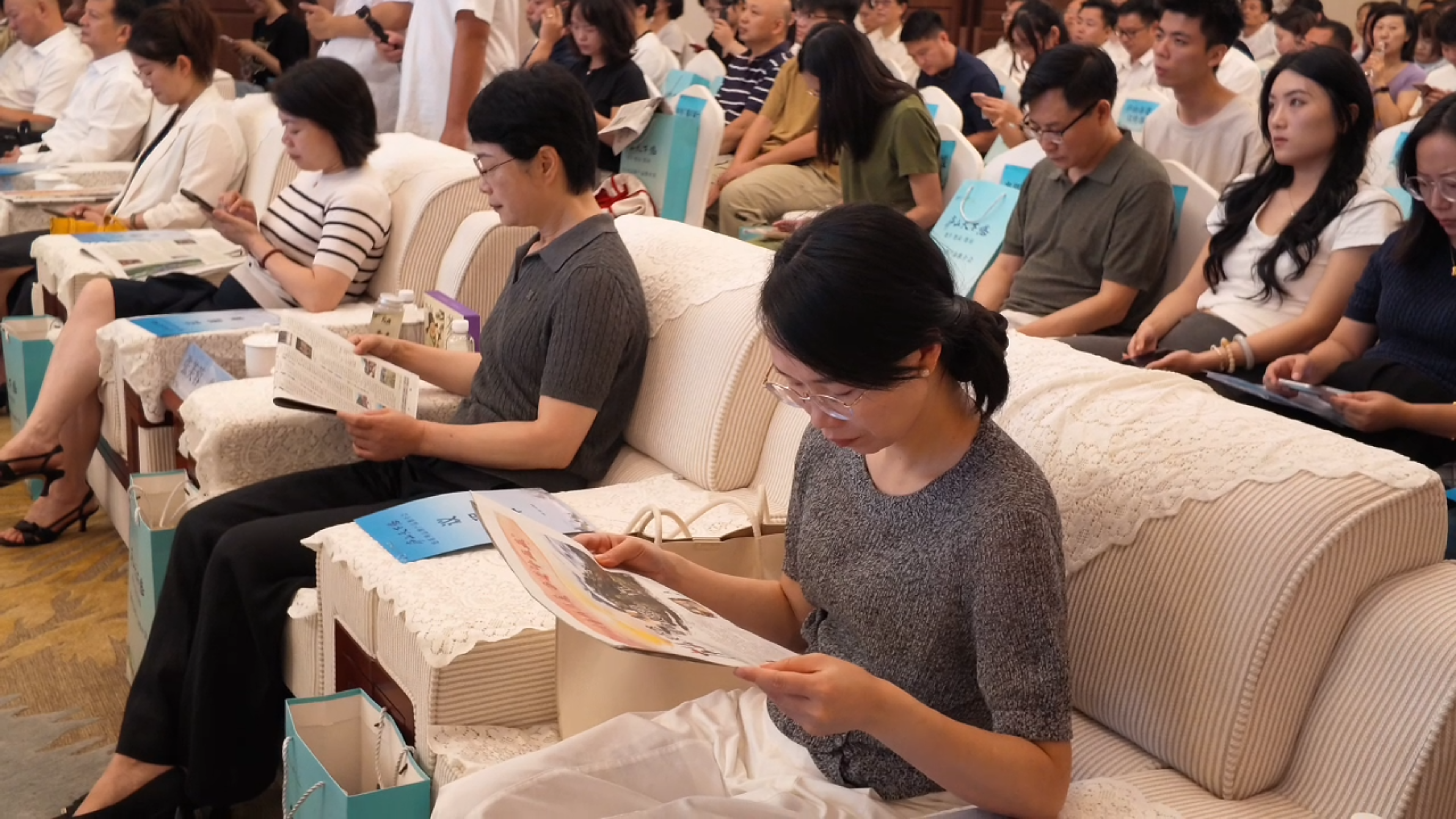 与会嘉宾阅读江西日报上关于庐山的报道。