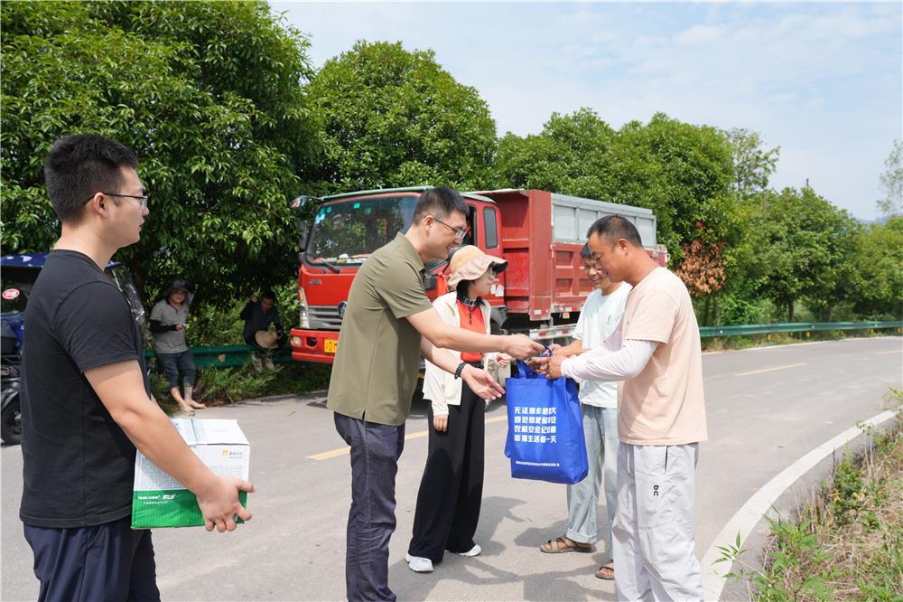 8月17日，屏锦镇和睦村，梁平区农业农村委工作人员给外地机手送上防暑用品。