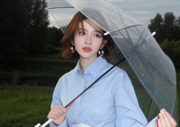 唐艺昕撑伞静立。