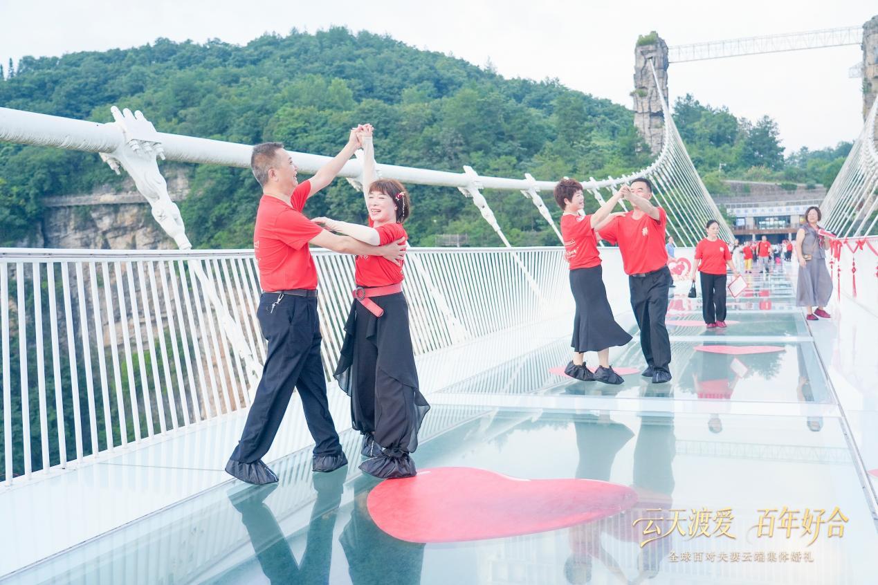 (集体婚礼结束后,夫妻在玻璃桥上情不自禁跳起交谊舞)
