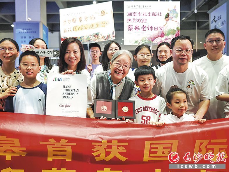 乘高铁回长的“宝藏奶奶”蔡皋（中）与迎接她的读者一起合影。长沙晚报全媒体记者 柳静芸 摄