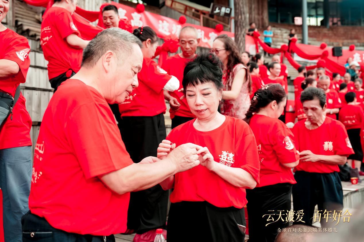 (集体婚礼现场,夫妻交换戒指)