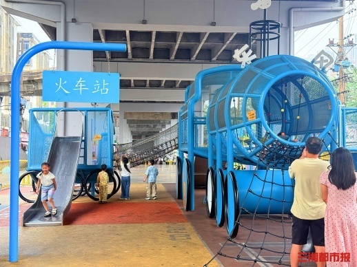 东风路立交桥下运动空间，孩子们在游乐设施上玩耍。