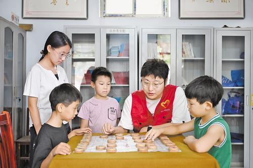 8月1日，在邢台市任泽区辛店镇双蓬头村暑期公益托管班，大学生志愿者教小学生下象棋。本报记者 赵永辉摄