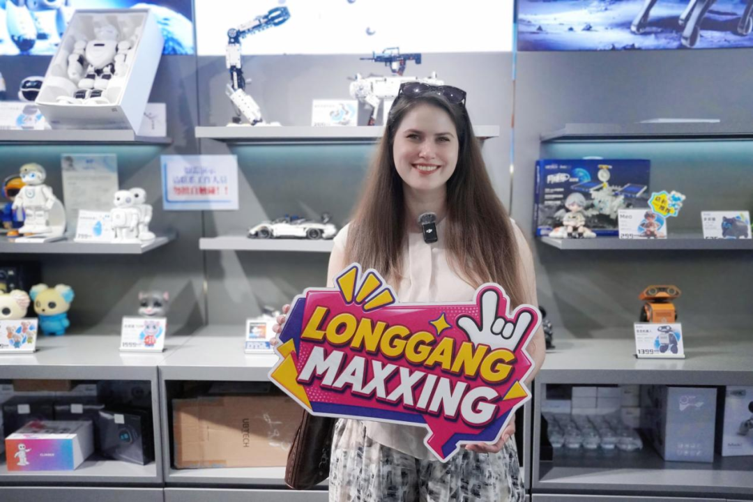 外国友人刘欢在机器人6S店手持Langgangmaxxing KT板合影。(叶惠玲 摄)