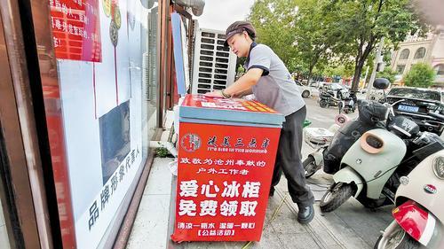 日前,沧州市“凌晨三点半”焖饼烩饼店工作人员在擦拭爱心冰柜。乔宾娟摄