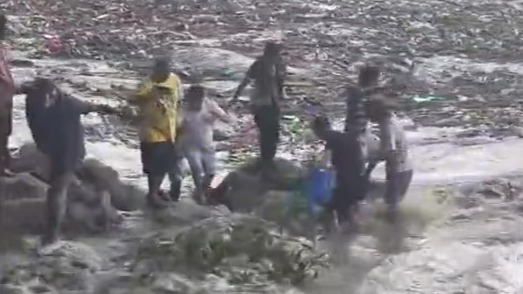 现场画面：洪流滚滚而过，尼泊尔民众冒险在岸边打捞物资